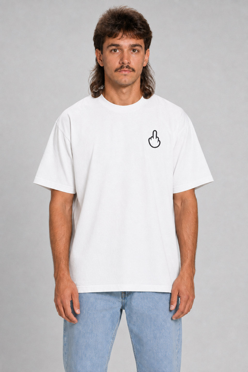A man wearing a white crewneck t-shirt with a small black hand graphic on the left chest, paired with light blue jeans, standing against a neutral gray background. #white